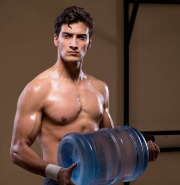 Büyük su şişeli kaslı adam.