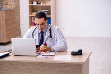 Klinikte çalışan genç erkek doktor kardiyolog.