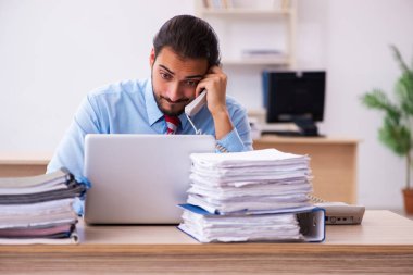 Ofisteki aşırı işten memnun olmayan genç bir erkek işçi.