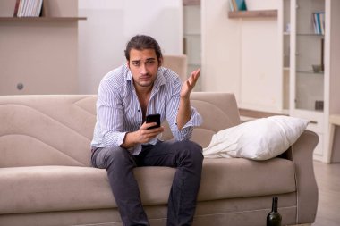 Genç sarhoş adam evde acı çekiyor.