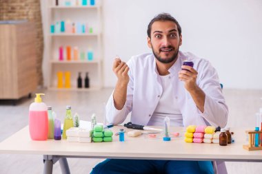 Genç erkek kimyager laboratuarda sabun test ediyor.