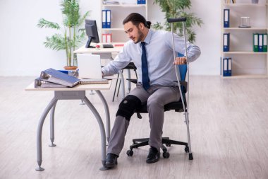 Ofiste çalışan genç bacağı yaralı bir çalışan.