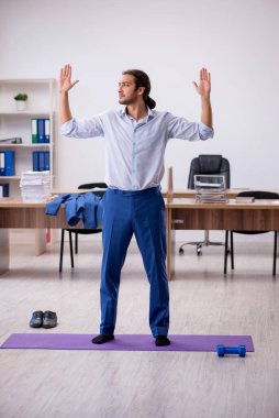 Mola sırasında spor yapan genç erkek çalışanlar.