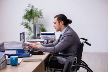 İş yerindeki tekerlekli sandalyede oturan genç bir erkek.