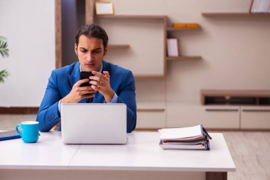 Genç erkek çalışan salgın sırasında evden çalışıyor.