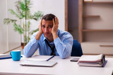 Genç erkek çalışan salgın sırasında evden çalışıyor.