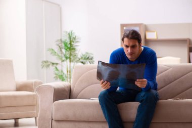 Evde acı çeken genç hasta adam.