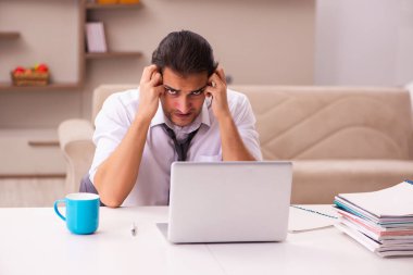 Genç erkek çalışan salgın sırasında evden çalışıyor.