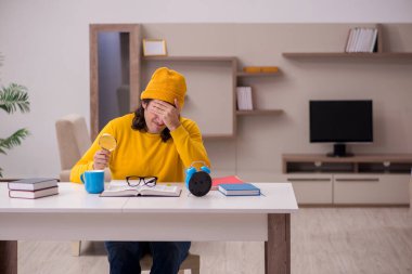 Evde sınava hazırlanan genç bir erkek öğrenci.