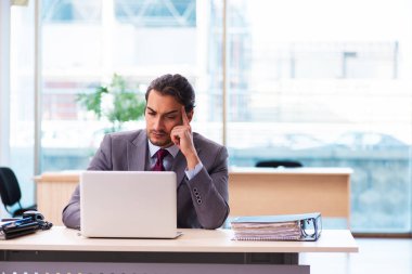 Ofiste çalışan genç bir erkek.