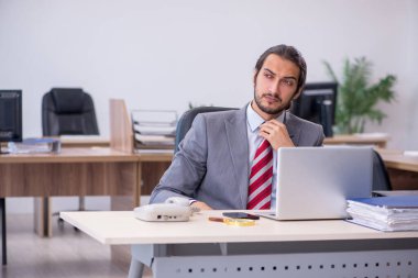 Ofiste çalışan genç bir erkek.