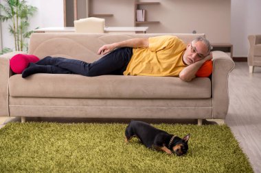 Evde köpeği olan yaşlı bir adam.