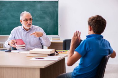 Yaşlı erkek öğretmen ve okul çocuğu sınıfta.