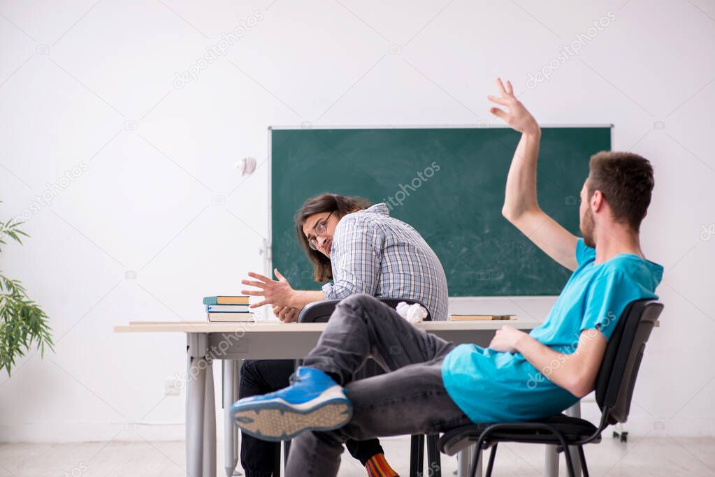 Two male pupils in bullying concept in the classroom