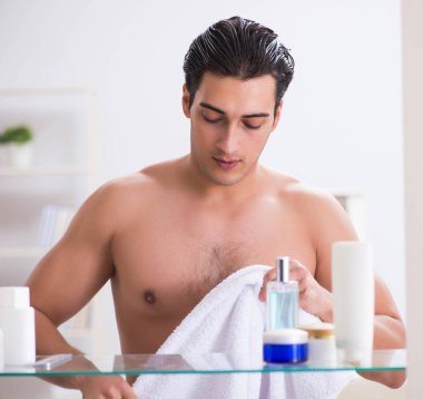 Genç adam banyoda çalışmak için hazırlanıyor.