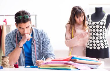 Atölyede erkek terzi ve bayan öğrenci.