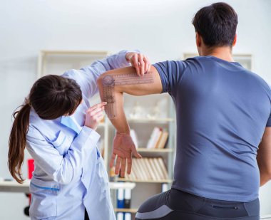 Doktor hastaların eklem esnekliğini gonimetreyle kontrol ediyor.