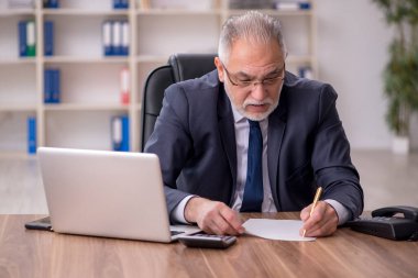 Ofiste çalışan yaşlı bir erkek.