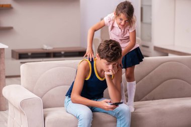 Oğlan ve küçük kız kardeşi salgın sırasında evde kalıyorlar.