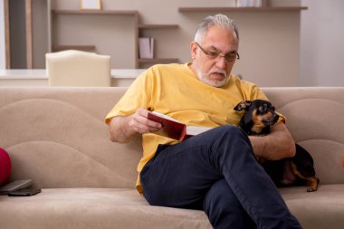 Evde köpeği olan yaşlı bir adam.