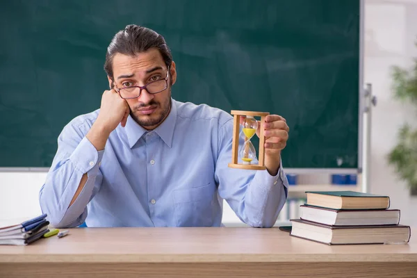 Junge männliche Lehrer im Klassenzimmer im Zeitmanagement-Konzept — Stockfoto