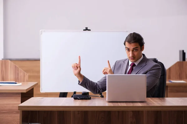 Young male business trainer in the office during pandemic