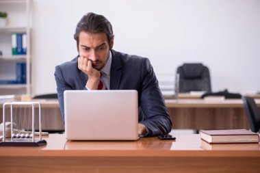 Genç işadamı ofiste oturuyor.