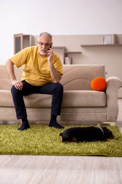 Evde köpeği olan yaşlı bir adam.