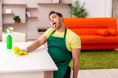 Genç müteahhit evin içini temizliyor.