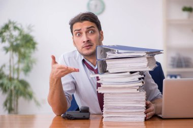 Genç işadamı ve ofiste çok fazla iş var.