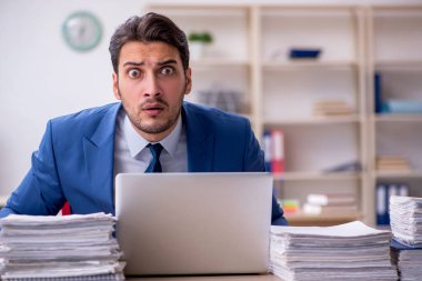 Genç işadamı ve ofiste çok fazla iş var.