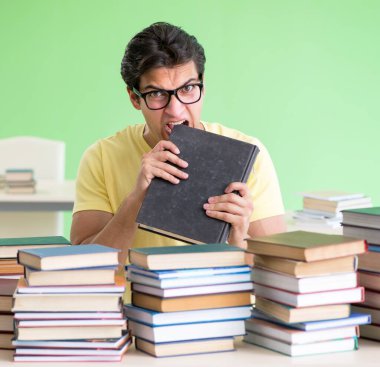 Sınavdan önce okumak için çok fazla kitabı olan öğrenci