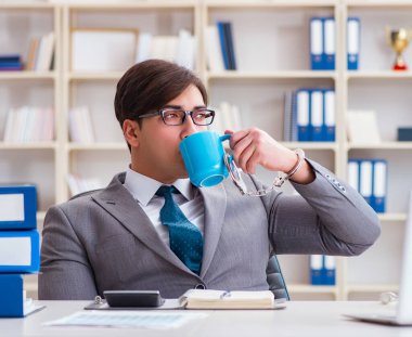 Kahvesine kelepçelenmiş bir iş adamı.