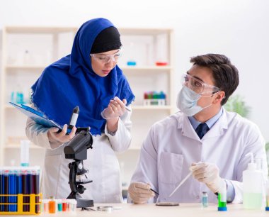 Laboratuvarda çalışan iki kimyager.