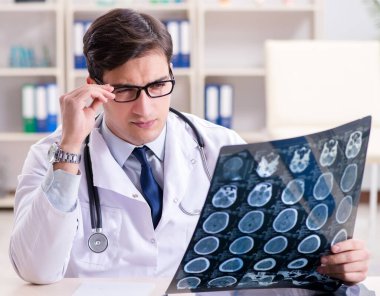 Genç doktor klinikteki röntgen görüntülerine bakıyor.