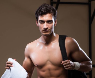 Spor salonunda idman yaptıktan sonra yorgun bir adam.