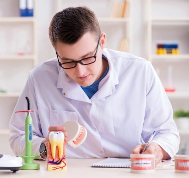 Tıp laboratuarına diş implantı yerleştiren dişçi.