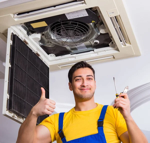 Repairman repairing ceiling air conditioning unit