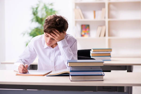 Skolpojke förbereder sig för tentor i klassrummet — Stockfoto