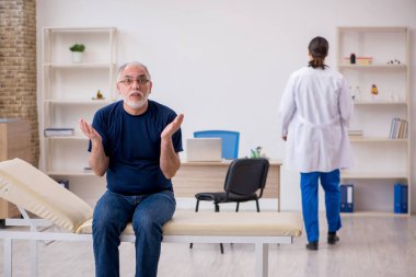 Yaşlı erkek hasta genç erkek doktoru ziyaret ediyor.