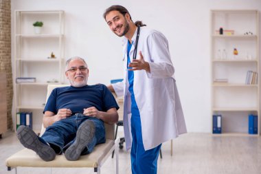 Yaşlı erkek hasta genç erkek doktoru ziyaret ediyor.