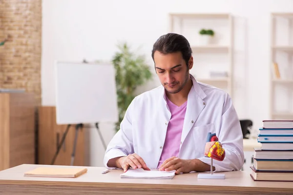 Молодий чоловік лікар студент кардіолог сидить у класі — стокове фото