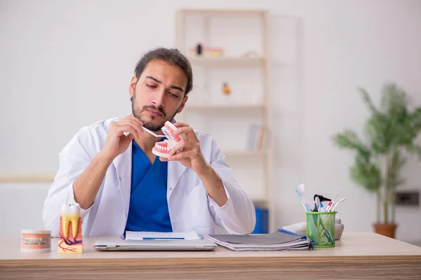 Jonge mannelijke tandarts docent werkzaam in de kliniek — Stockfoto