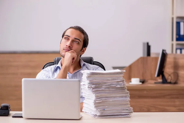 Junge männliche Mitarbeiter und viel Papierkram im Büro — Stockfoto