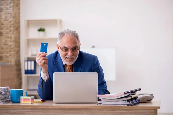 Velho empresário empregado segurando cartão de crédito no escritório — Fotografia de Stock