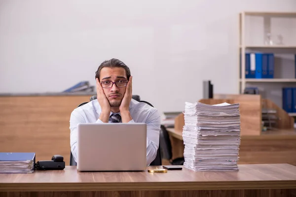 Jovem funcionário masculino infeliz com excesso de trabalho no escritório — Fotografia de Stock