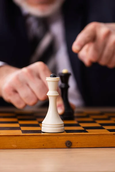 Old male employee playing chess at workplace — Stock Photo, Image