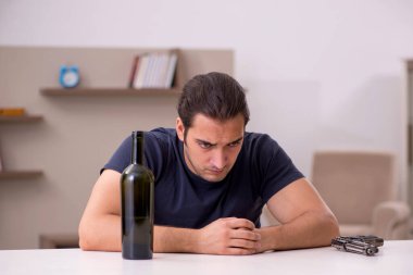 Genç erkek alkolik evde intihar ediyor.