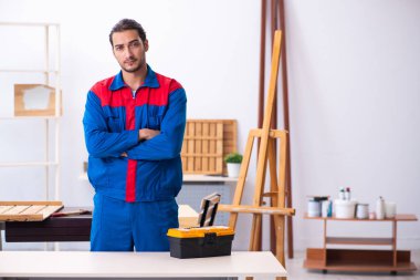 Genç erkek müteahhit atölyede çalışıyor.