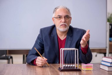 Sınıfta oturan eski bir fizikçi öğretmen.